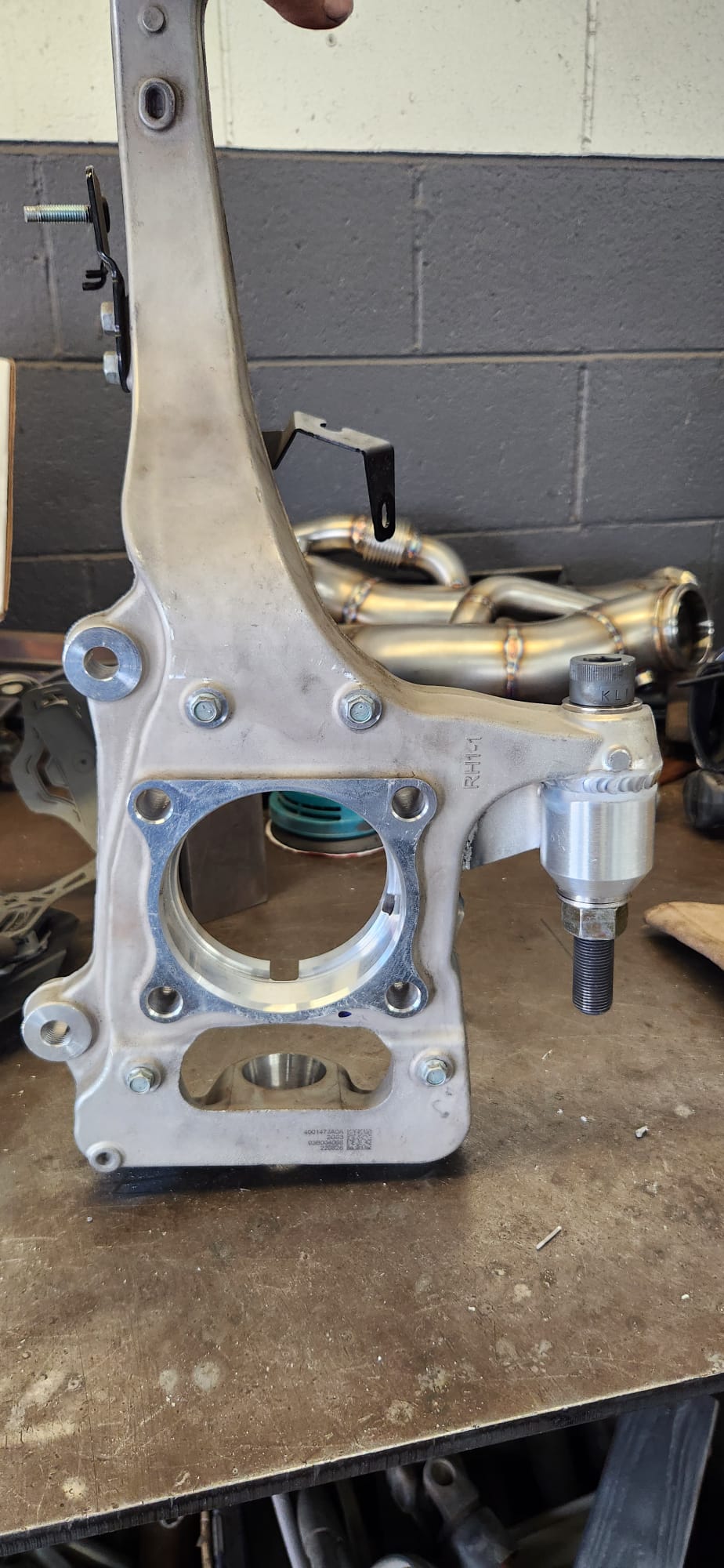 Custom twin turbo system with Garrett turbos and stainless exhaust piping on workbench — angle 2
