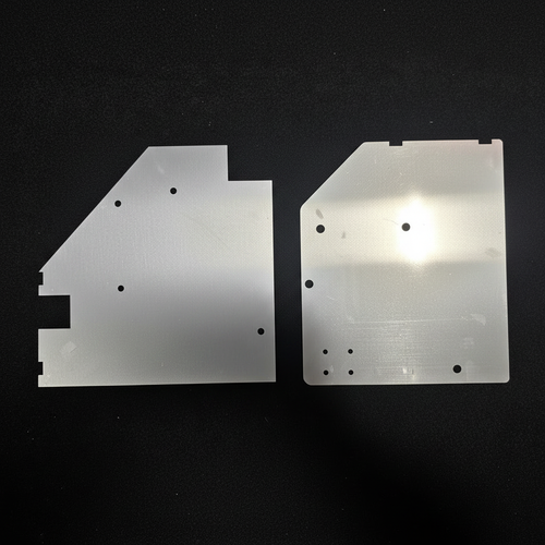 Two aluminum kick panel blanks for Datsun 260Z on black background